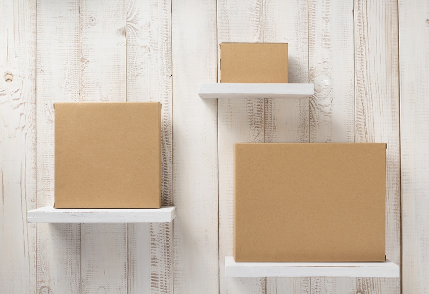 three cardboard box on  white wooden shelves