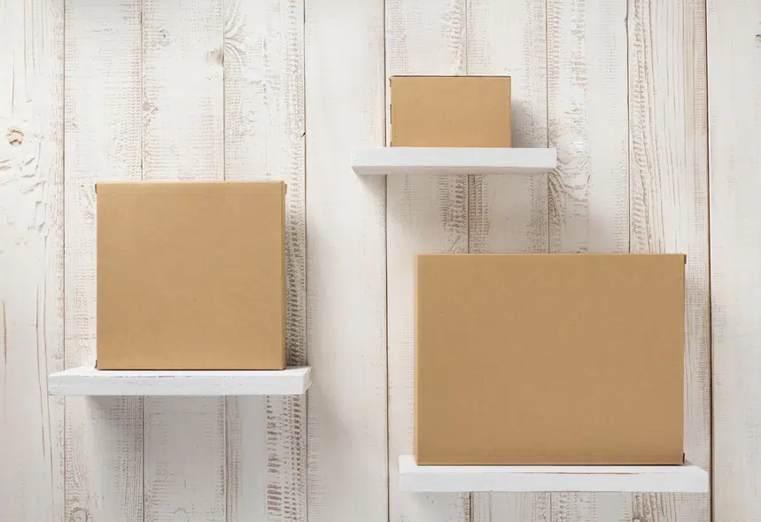 three cardboard box on white wooden shelves
