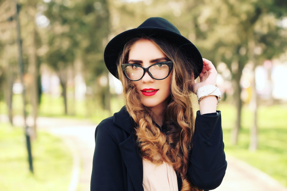 smiling blonde woman in sunglasses and vintage hat